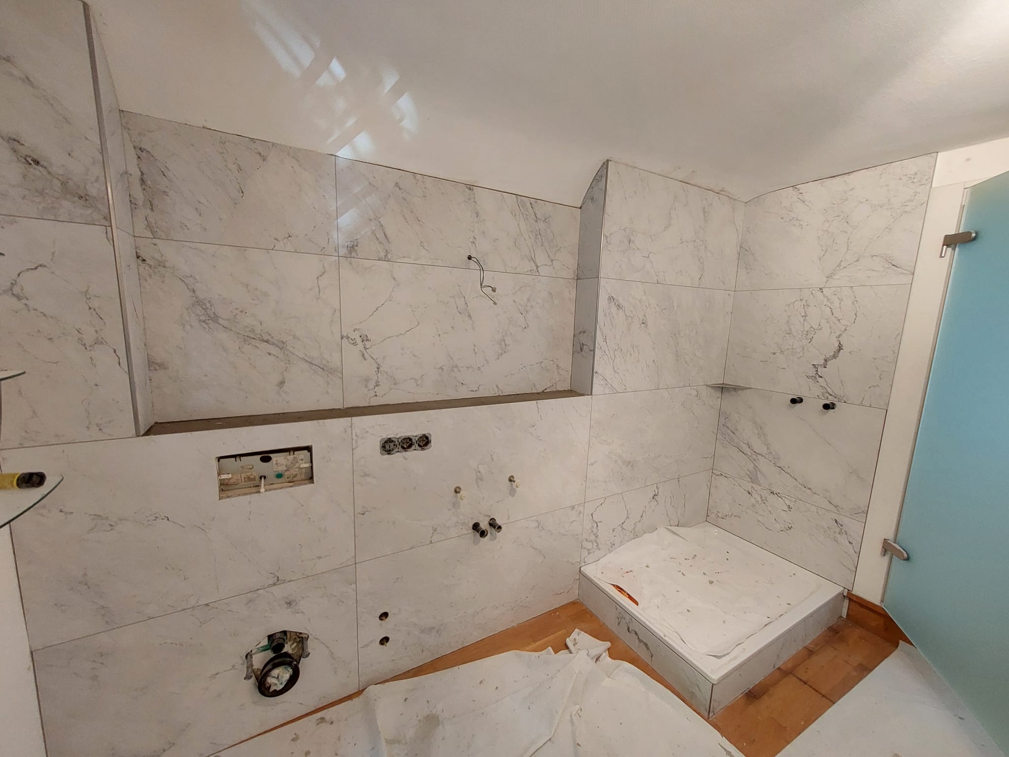 Großformatige Fliesenarbeiten in einem hellen Badbereich